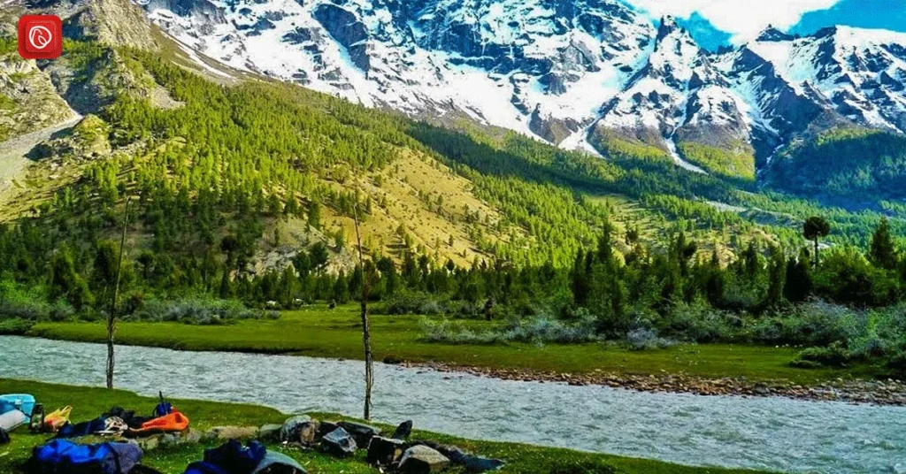 an image of basho valley in which camps are placed in front of river and beautiful snow-capped mounatins