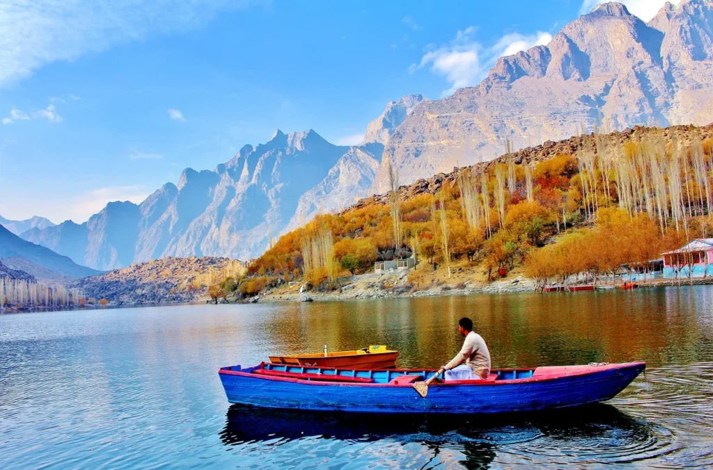 an image of kachura lake which is one of the best places to visit in skardu and one of the best tourist attractions in skardu. in image a man with his boat boating in the lake