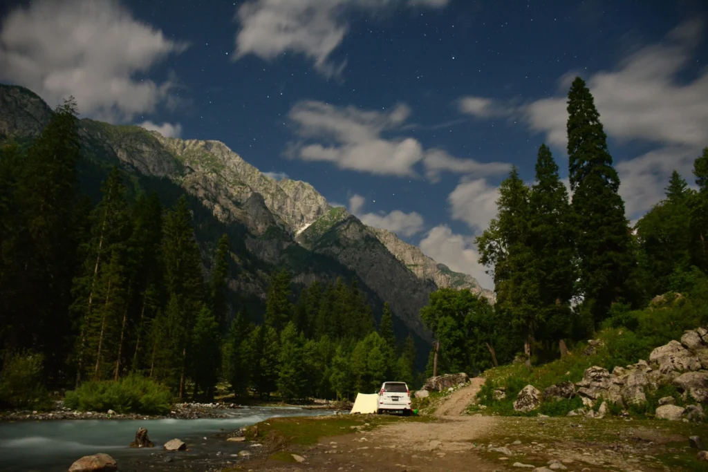 an image of flowing river surrounded by mountains and forests